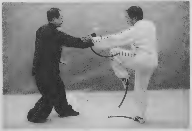 Trắng bước chân phải ra sau, nâng chân trái và dẫn đòn của Đen sang một bên